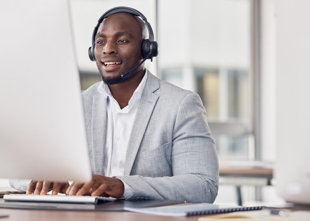 Call center, man and computer for typing with smile, reading and tech support with happiness at job